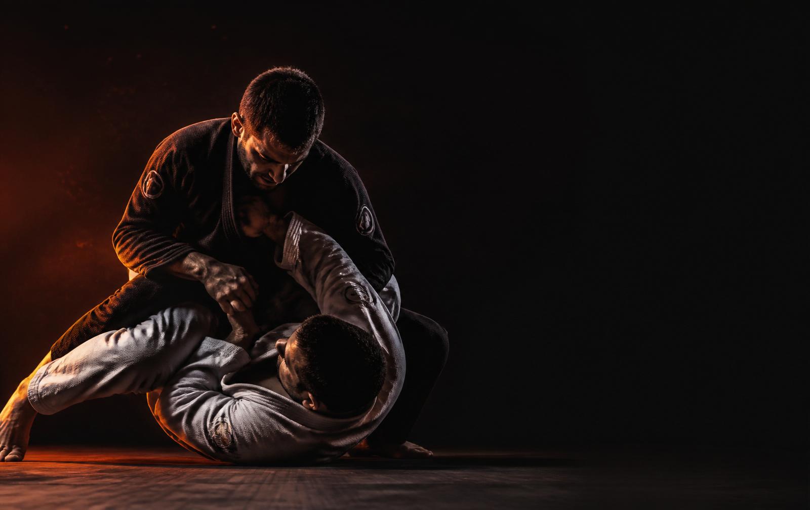 Two jiu-jitsu athletes grappling on the mat